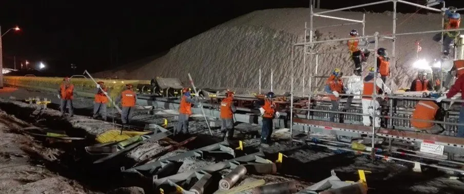 Trabajo nocturno en sistema transportador junto a un acopio
